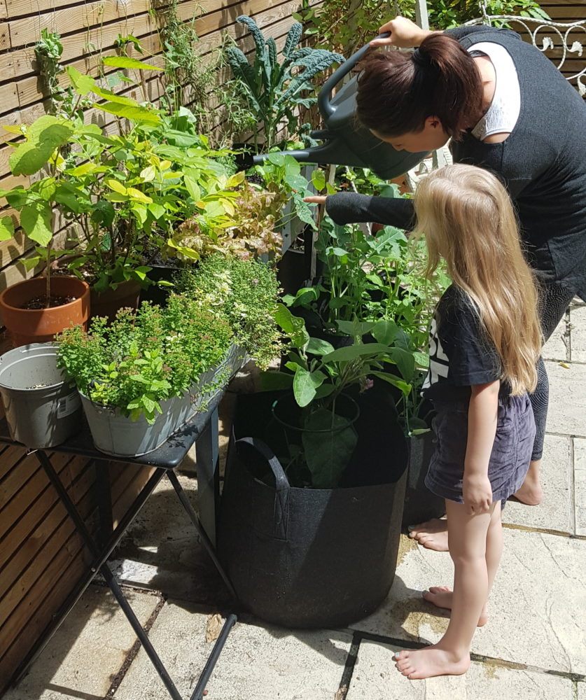 mother and child watering veg
